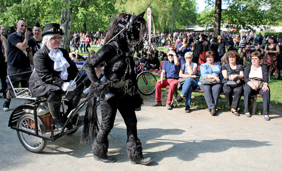 Eine Besucherin des Wave-Gotik-Treffens (WGT) lässt sich von einem menschlichen Pferd am 13.05.2016 durch den Clara-Zetkin-P