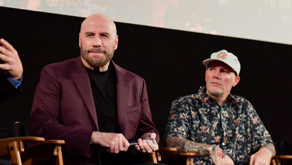 HOLLYWOOD, CALIFORNIA - AUGUST 22: John Travolta and Fred Durst speak onstage during the premiere of Quiver Distribution's 'T