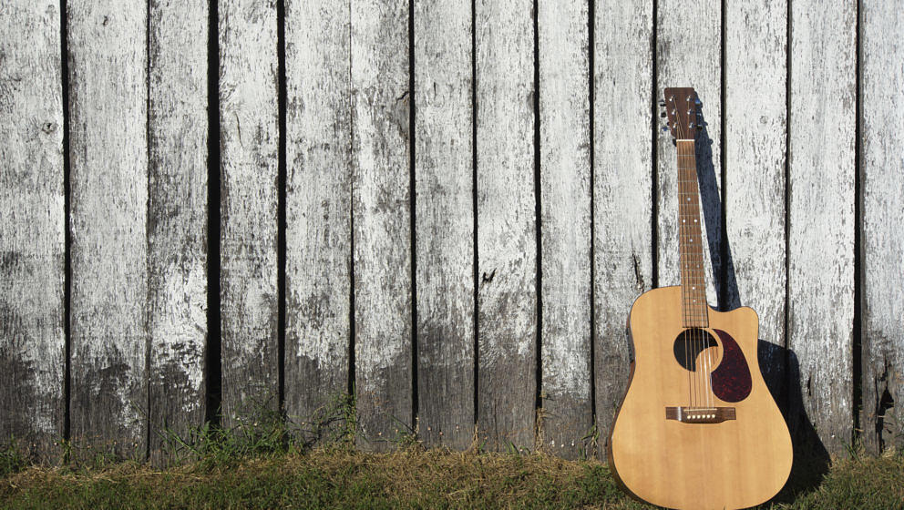 Dreadnought style acoustic guitar leans against barn outside Nashville, Tennessee, USA