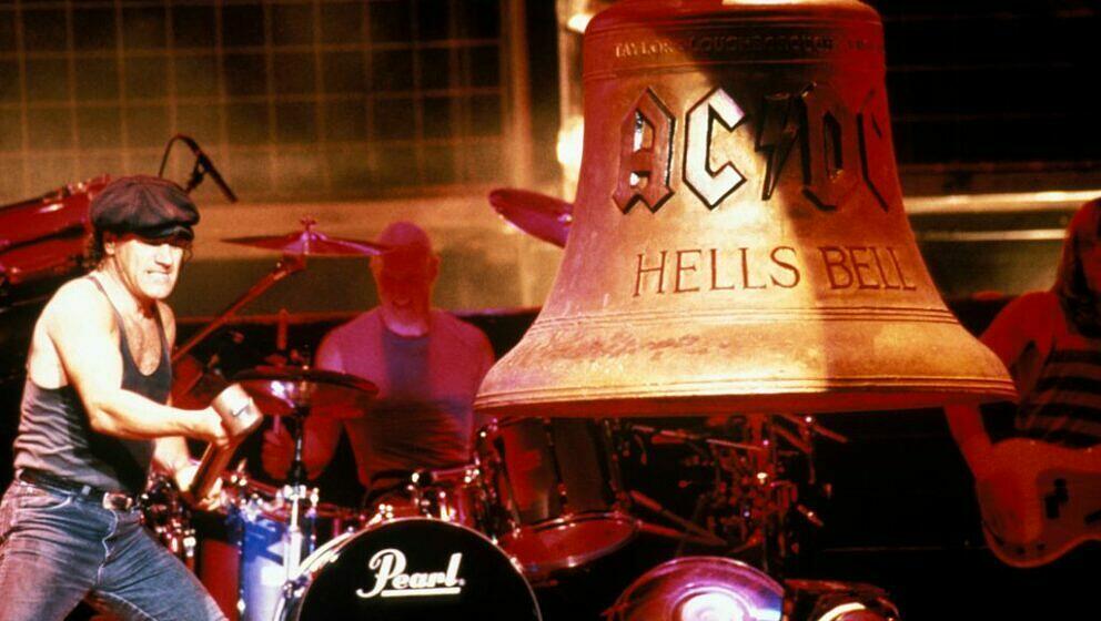 Brian Johnson schlägt mit einem Hammer die 'Hells Bells'-Glocke, im Hintergrund Chris Slade am Schlagzeug