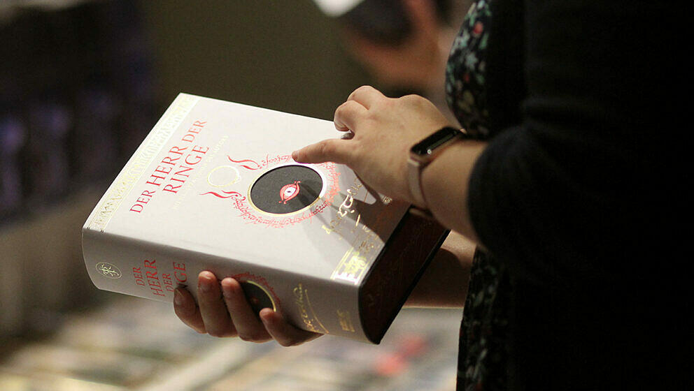 A visitor holds the book 'Lord of The Rings' at a booth at the Frankfurt Book Fair 2021 in Frankfurt am Main, Germany, on Oct